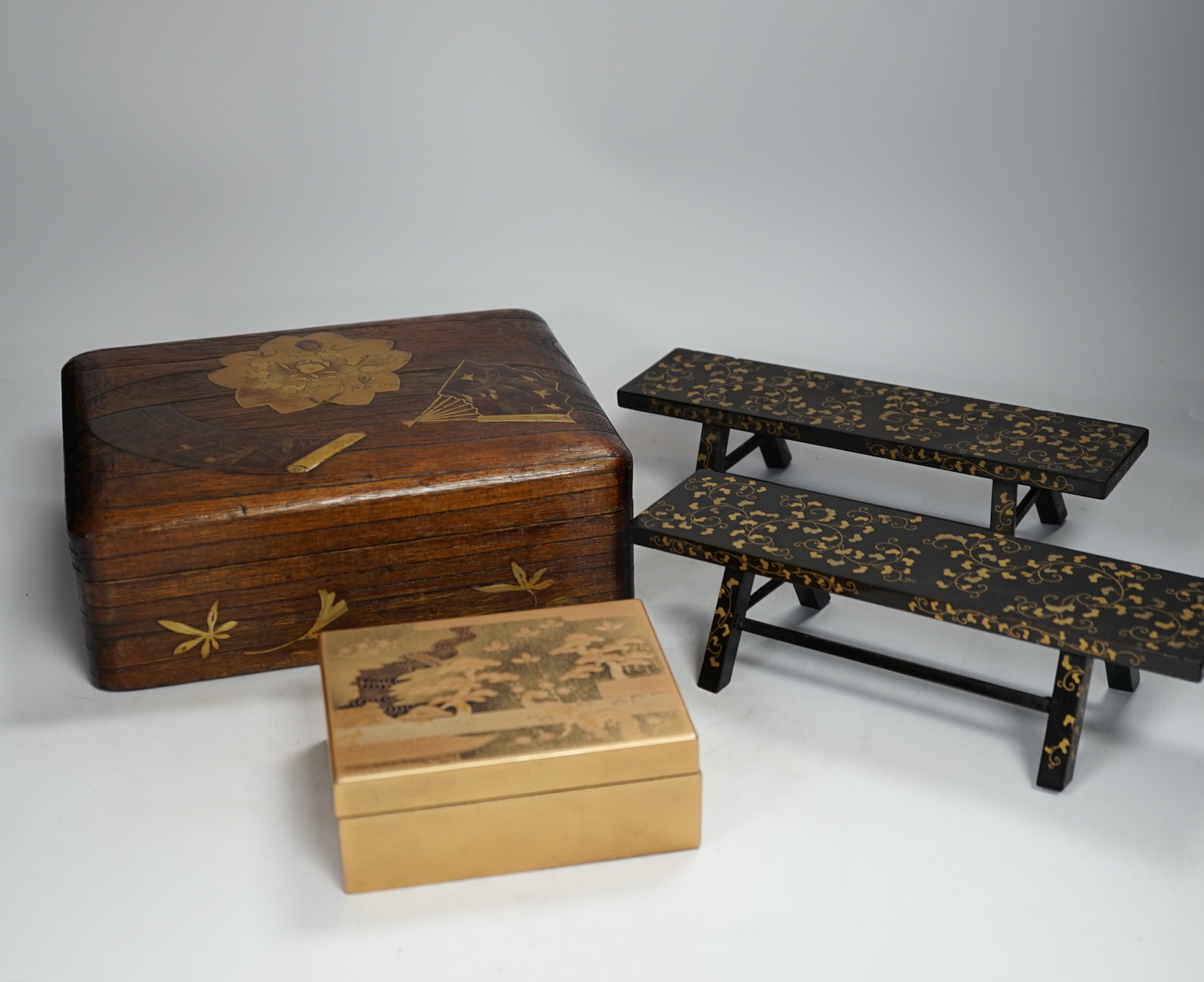 A group of Japanese lacquer wares, comprising pair of miniature benches and two boxes, Meiji period and later, largest 25cm wide